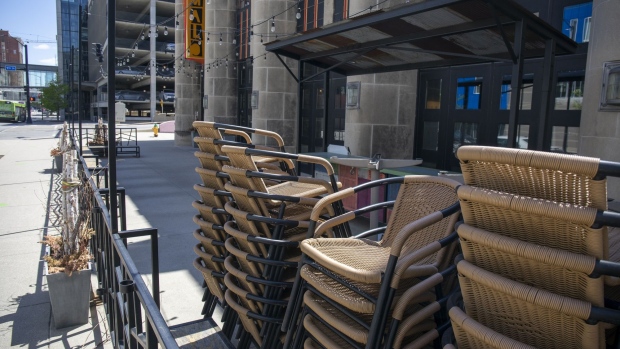 Patio furniture sits stacked outside a closed restaurant in downtown Des Moines, Iowa, U.S., on Friday, May 8, 2020. Governor Kim Reynolds announced Monday that she would relax restrictions on businesses like restaurants, fitness centers and malls in 77 of Iowa's 99 counties, taking effect May 1, the Des Moines Register reported. Photographer: Rachel Mummey/Bloomberg