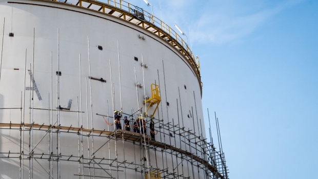 Workers stand on the scaffolding platform of a storage tank at the under-construction Dangote Industries Ltd. oil refinery and fertilizer plant site in the Ibeju Lekki district, outside of Lagos, Nigeria, on Thursday, July 5, 2018. The $10 billion refinery, set to be one of the world’s largest and process 650,000 barrels of crude a day, should be near full capacity by mid-2020, Devakumar Edwin, group executive director at Dangote Industries said in an interview. Photographer: Tom Saater/Bloomberg
