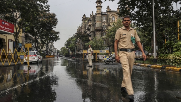 Police officers walk along an empty road during a lockdown imposed due to the coronavirus in Mumbai, India, on Monday, June 1, 2020. Despite a strict two-month-long lockdown, the outbreak in India’s financial capital has snowballed, with the city now accounting for nearly a quarter of India’s more than 4,700 deaths and more a fifth of India’s over 165,000 infections. Photographer: Dhiraj Singh/Bloomberg
