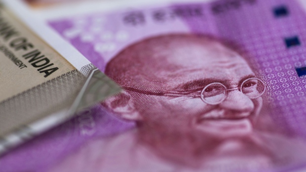 The portrait of Mahatma Gandhi is displayed on an Indian 2,000 rupee banknote in an arranged photograph in Bangkok, Thailand, on Wednesday, Sept. 12, 2018. India's rupee dropped to a record low before trimming last week's loss; the government unveiled measures to prop up the sagging currency, including steps to facilitate bond issuance by local companies and possible curbs on imports. Photographer: Brent Lewin/Bloomberg