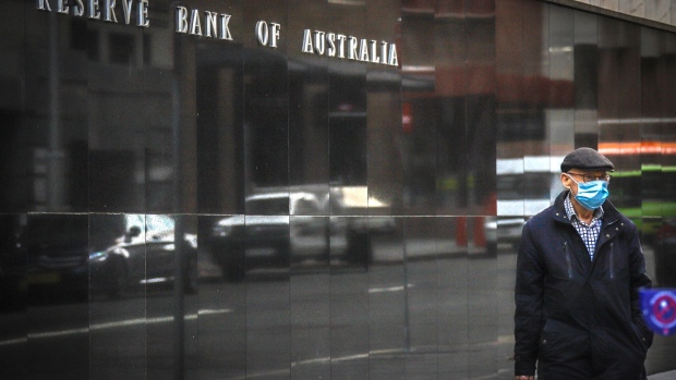 A pedestrian wearing a face mask walks past the Reserve Bank of Australia (RBA) building, during a partial lockdown imposed due to the coronavirus, in Sydney, Australia, on Monday, May 18, 2020. Australia’s central bank decided against buying government bonds last week, the first time that’s happened since it began a quantative easing program in late March that sought to hold down three-year yields in order to lower interest rates across the economy. Photographer: David Gray/Bloomberg