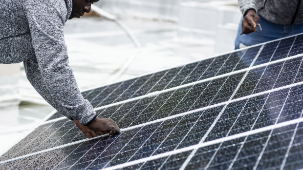 Workers install solar panels onto the roof of a residential property in Johannesburg, South Africa, on Friday, Mar. 13, 2020. The coronavirus lockdown will cause the biggest drop in energy demand in history, with only renewables managing to increase output through the crisis. Photographer: Waldo Swiegers/Bloomberg