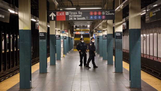 NYPD officers wearing protective masks patrol a Times Square subway platform. Photographer: Michael Nagle/Bloomberg