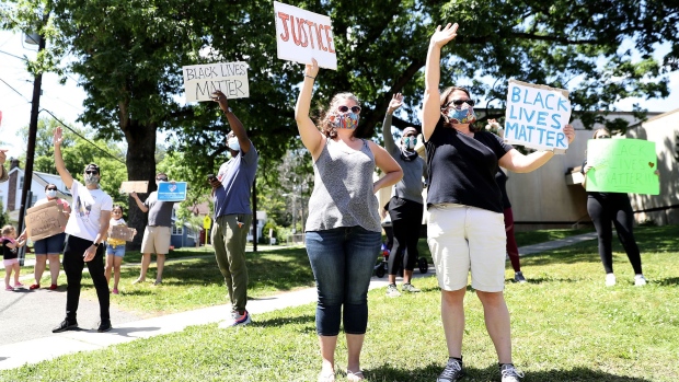 WEST ORANGE, NEW JERSEY - MAY 31: Residents of West Orange wave to passing motorists as they gather to protest the death of George Floyd on May 30, 2020 in West Orange, New Jersey. Protests continue to be held in cities throughout the country over the death of George Floyd, a black man who was killed in police custody in Minneapolis on May 25. (Photo by Elsa/Getty Images)