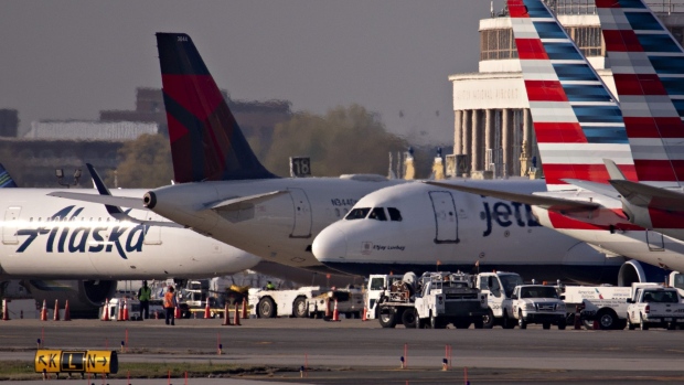 A JetBlue Airways Corp. plane taxis next to American Airlines Group Inc., Delta Air Lines Inc., and Alaska Airlines Inc. aircraft at Reagan National Airport (DCA) in Arlington, Virginia, U.S., on Monday, April 6, 2020. U.S. airlines are applying for federal aid to shore up their finances as passengers stay home amid the coronavirus pandemic. Photographer: Andrew Harrer/Bloomberg