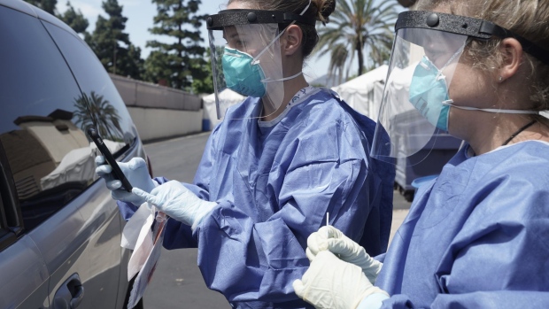 Nurses wearing personal protective equipment (PPE) prepare to collect a nasal swab specimen from a patient at a Covid-19 drive-through testing site at the North Inland Live Well Escondido Center in Escondido, California, U.S., on Thursday, April 30, 2020. People on Medicare will no longer require a doctor’s order to get tested for Covid-19, the Trump administration said Thursday. Photographer: Bing Guan/Bloomberg