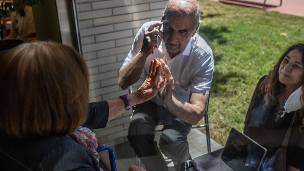 ESPLUGUES DEL LLOBREGAT, SPAIN - MAY 19: Concepcio Zendrera, 100 tries to touch the hand of her son Santi during a visit through a window at La Mallola nursing home on May 19, 2020 in Esplugues del Llobregat, near Barcelona, Spain. As measures ease in Spain, nursing homes remains still locked down to protect elderly people and prevent new outbreaks. La Mallola nursing home has started a program of visits for relatives of residents using one of their big windows. Many of the hundreds of thousand of residents in Spain's nursing homes are already at risk for loneliness, which research shows can undermine their physical and mental health due to the strict quarantine measure to fight the novel coronavirus. This program aims to improve the lockdown of elderly people living in this nursing home as they approach their third month without visits of their close relatives. Over 18,000 elderly people in nursing homes have died in Spain due to COVID-19 pandemic. (Photo by David Ramos/Getty Images)