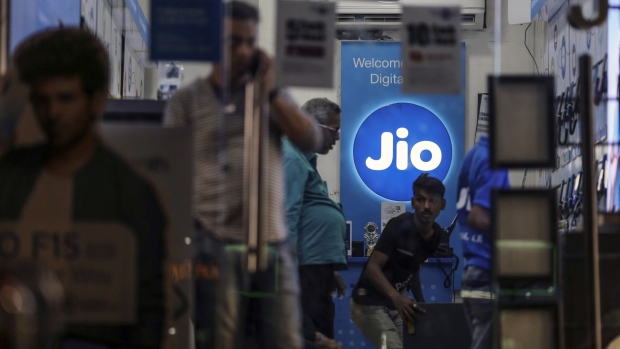 The logo of Reliance Jio, the mobile network of Reliance Industries Ltd., is displayed inside a store in Mumbai, India, on Sunday, Jan. 19, 2020. Reliance Industries, India's biggest company by market value, posted a 13.5% jump in quarterly net income as growth in telecom and retail business helped outweigh a slump in petrochemical operations. Photographer: Dhiraj Singh/Bloomberg