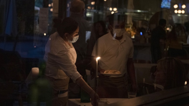 Waiters deliver food to a table at a restaurant after coronavirus disease restrictions were lifted in Houston on May 27.