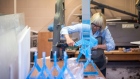 A worker assembles a counter-top shield at the Plexi-Klass plastics