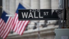 A sign for Wall Street and American flags in New York, U.S.. Bloomberg/Michael Nagle