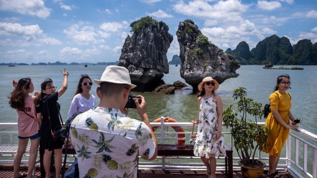 QUANG NINH, VIETNAM - MAY 31: Vietnamese tourists pose for photographs on a boat touring Ha Long Bay, after the Vietnamese government eased the lockdown following the coronavirus disease (COVID-19) outbreak, on May 31, 2020 in Ha Long, Quang Ninh Province, Vietnam. Though some restrictions remain in place, Vietnam has lifted the ban on domestic travel, certain entertainment facilities and non-essential businesses to revive its economy. As of May 31, Vietnam has confirmed 328 cases of coronavirus disease (COVID-19 ) with no deaths in the country, 279 fully recovered and no new case caused by community transmission for 46 days. (Photo by Linh Pham/Getty Images)
