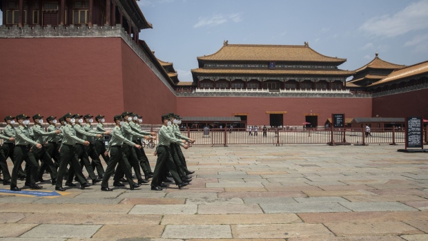 People's Liberation Army soldiers wearing protective masks march past the Forbidden City in Beijing, China, on Friday, May 22, 2020. China confirmed on Friday that it would effectively bypass Hong Kong's legislature to implement national security laws, which have long been resisted by residents who fear they will erode freedoms of speech, assembly and the press. Photographer: Qilai Shen/Bloomberg