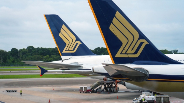Singapore Airlines Ltd. aircraft stand on the tarmac at Changi Airport in Singapore, on Thursday, Dec. 13, 2018. Singapore's Changi Airport, voted the world's best for the past six years by Skytrax, is pursuing that goal of extensive automation with such vigor that it built Terminal 4 to help test the airport bots of the future. Photographer: Nicky Loh/Bloomberg