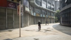 A cyclist rides past closed stores on a deserted street in Wuhan, China, on Friday, May 1, 2020. 