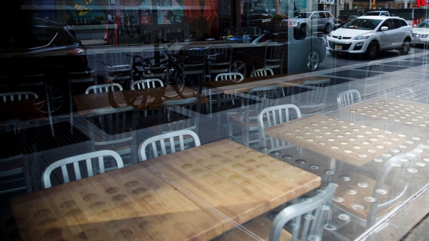 Chairs and tables sit inside a closed restaurant in Times Square in New York on April 21. Photographer: Michael Nagle/Bloomberg