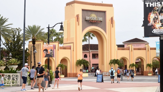 Park guests wearing protective masks arrive at the Universal Studios in Orlando on June 5