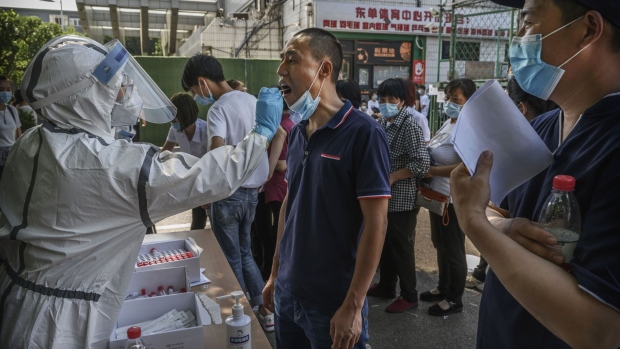 A Chinese epidemic control worker wears a protective suit and mask while performing a nucleic acid test for COVID-19 on a man who has had contact with the Xinfadi Wholesale Market or someone who has, at a testing center on June 16, 2020 in Beijing, China. 