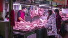 Customers wearing protective masks look at pork for sale at a market in Shanghai