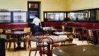 A worker walks past empty tables inside a restaurant in Montclair, New Jersey on June 15. Photographer: Gabby Jones/Bloomberg