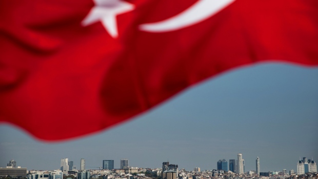Buildings on the skyline of the European side sit on the horizon, framed beneath a Turkish flag flying from the Asian side, in Istanbul, Turkey, on Monday, April 27, 2020. Coming off a brief recession just over a year ago, the urgency is mounting for Turkey to loosen the screws on the economy as its currency and reserves come under pressure more than a month after it introduced social-distancing measures. Photographer: Kerem Uzel/Bloomberg