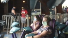 Visitors wear protective masks while sitting on a roller coaster at the SeaWorld amusement park in Orlando, Florida, U.S., on Thursday, June 11, 2020. After an almost three-month closure because of the coronavirus pandemic, SeaWorld will reopen its parks this week with new measures designed to safeguard employees and visitors.