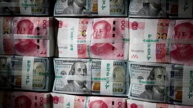 Genuine bundles of Chinese one-hundred yuan banknotes and U.S. one-hundred dollar banknotes are arranged for a photograph at the Counterfeit Notes Response Center of KEB Hana Bank in Seoul, South Korea, on Friday, July 13, 2017. Yuan is set to slide for fifth week, longest losing streak since July 2016, as escalating U.S.-China trade tensions weigh on sentiment. Photographer: SeongJoon Cho/Bloomberg
