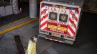 A medical worker wearing protective gear walks by a Fire Department of New York (FDNY) ambulance outside the emergency room at Montefiore Hospital in the Bronx borough of New York, U.S., on Thursday, April 2, 2020. Photographer: David Dee Delgado/Bloomberg