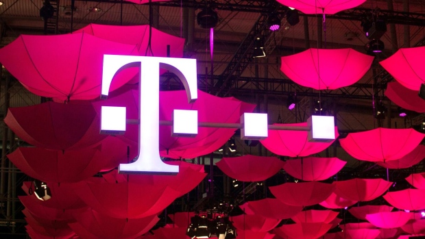 The T-Mobile logo for Deutsche Telekom AG's T-Systems unit, is seen suspended from the ceiling along with a collection of coloured umbrellas during the CeBit tech show in Hanover, Germany.