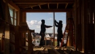 Construction workers install frames for windows and doors in a home being built in Michigan. Photographer: Emily Elconin/Bloomberg
