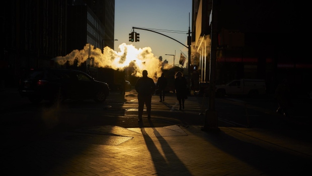 Steam rises as pedestrians cross a street near the New York Stock Exchange (NYSE) in New York, U.S., on Thursday, Dec. 27, 2018. Volatility returned to U.S. markets, with stocks tumbling back toward a bear market after the biggest rally in nearly a decade evaporates.