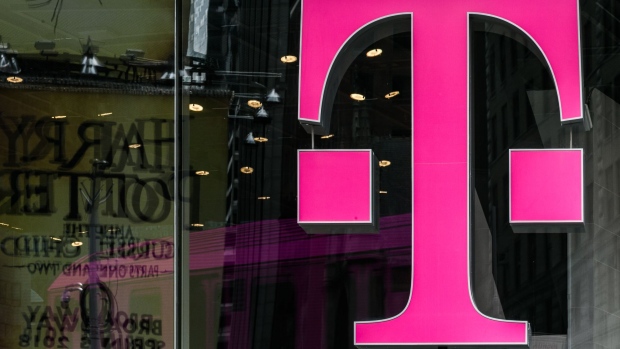 A T-Mobile US Inc. logo is displayed on a store location in New York, U.S., on Monday, April 30, 2018. Sprint Corp. suffered its worst stock decline in almost six months, rocked by fears that a proposed $26.5 billion takeover by T-Mobile US Inc. will get rejected by antitrust enforcers. Photographer: Jeenah Moon/Bloomberg