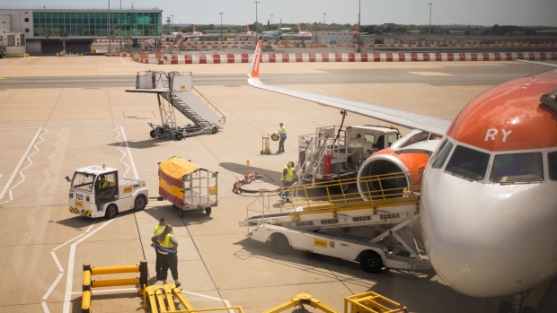 Ground staff prepare a passenger flight, operated by EasyJet Plc, at a gate at London Gatwick Airport in Crawley, U.K., on Monday, June 22, 2020. European airlines are in a worse situation than previously estimated as the coronavirus crisis depresses travel markets, according to economists at the International Air Transport Association. Photographer: Jason Alden/Bloomberg