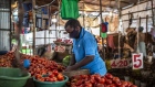 A vendor wearing a protective face mask arranges fresh tomatoes for sale on his stall at Toi market in Nairobi, Kenya, on Tuesday, May 26, 2020. Kenya plans to spend 53.7 billion shillings ($503 million) on a stimulus package to support businesses that have been hit by the coronavirus pandemic, according to the National Treasury. Photographer: Patrick Meinhardt/Bloomberg