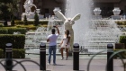 A couple takes photographs in front of the fountains at Caesars Entertainment Corp.'s Caesars Palace hotel in Las Vegas, Nevada, U.S., on Thursday, June 4.