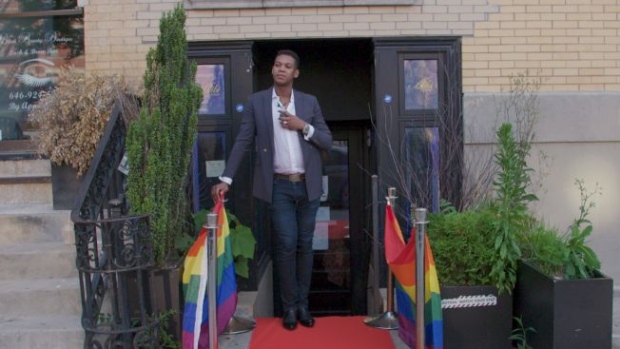 Owner Alexi Minko stands at the door of Alibi Lounge, which he says is Manhattan’s only Black-owned LGBTQ bar.