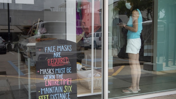 A "Face Masks Are Required" sign is displayed inside a store in Houston, Texas. Photographer: Callaghan O'Hare/Bloomberg