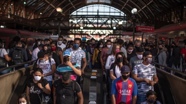 Commuters wearing protective masks walk onto excalators inside the Luz train station in Sao Paulo, Brazil, on Monday, June 22, 2020. Latin America's most populous country is only the second nation to reach the grim milestone of 1 million cases and, like in the U.S., the surge can be traced to reopenings and social distancing measures being lifted.