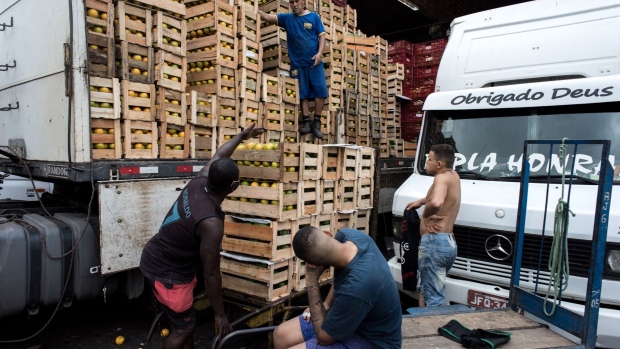 Workers move crates of fresh food at the CEASA market and distribution center in Rio de Janeiro. Photographer: Leonardo Carrato/Bloomberg
