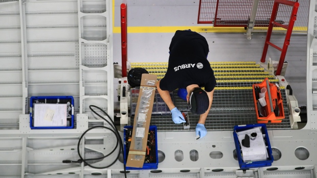 An employee works on a section of fuselage inside the new Airbus SE A320 passenger aircraft family assembly line hangar in Hamburg, Germany, on Tuesday, Oct. 1, 2019. An escalating battle over aircraft subsidies between the U.S. and the European Union threatens to damage both sides, said Airbus Chief Executive Officer Guillaume Faury.