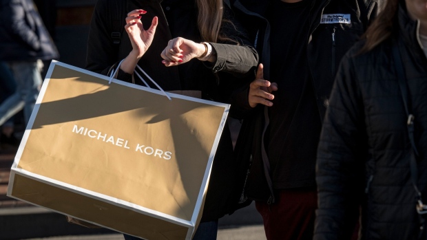 A pedestrian carries a Michael Kors USA Inc. shopping bag in San Francisco, California, U.S., on Thursday, Dec. 26, 2019. Confidence among U.S. consumers advanced to a nine-week high on greater optimism about the economy and brighter views of personal finances and the buying climate. Photographer: David Paul Morris/Bloomberg