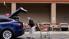 A customer wears a protective mask while loading purchases into a vehicle outside a Home Depot Inc. store in Reston, Virginia, U.S., on Thursday, May 21, 2020. Home Depot Inc. this week fell as the cost of Covid-19 measures offset higher sales, tempering financial gains from renewed consumer interest in home-improvement projects. Photographer: Andrew Harrer/Bloomberg