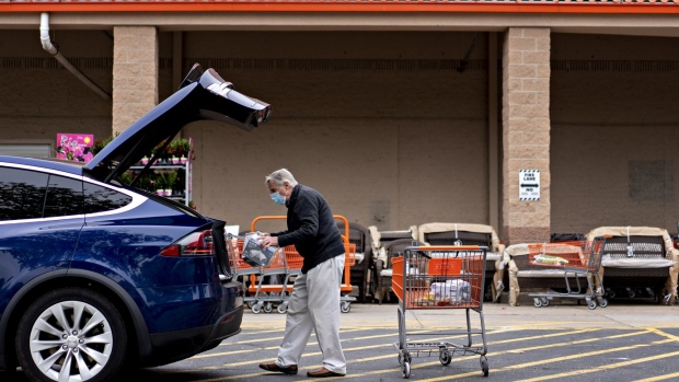 A customer wears a protective mask while loading purchases into a vehicle outside a Home Depot Inc. store in Reston, Virginia, U.S., on Thursday, May 21, 2020. Home Depot Inc. this week fell as the cost of Covid-19 measures offset higher sales, tempering financial gains from renewed consumer interest in home-improvement projects. Photographer: Andrew Harrer/Bloomberg