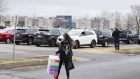 A shopper carries a purchase through a parking lot outside a Staples Canada Inc. Bureau En Gros store in Quebec City, Quebec, Canada, on Monday, May 4, 2020. The province, which accounts for more than half of Canada's deaths from Covid-19, is letting stores outside of Montreal resume business on May 4 -- as long as they have a street entrance, because enclosed shopping centers remain closed.