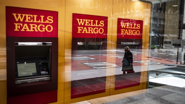A person wearing a protective mask is reflected in the window of a temporarily closed Wells Fargo & Co. Bank branch in New York, U.S., on Friday, April 10, 2020. Wells Fargo is scheduled to release earnings figures on April 14.