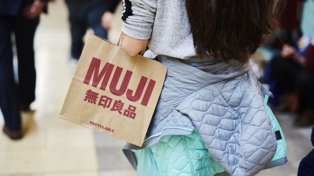 A customer holds a Muji shopping bag while walking through the Westfield Garden State Plaza mall on Black Friday in Paramus, New Jersey, U.S., on Friday, Nov. 29, 2019. U.S. shoppers are expected to spend around $32 billion on Black Friday, according to Customer Growth Partners' President Craig Johnson. Photographer: Gabby Jones/Bloomberg