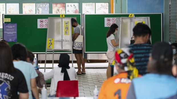 Voters fill in their ballot papers at booths at the Poi Ching School polling station in Singapore, on Friday, July 10, 2020. Singapore headed to the polls as Prime Minister Lee Hsien Loong’s ruling party seeks to extend its 55-year rule with a fresh mandate to counter the city-state’s worst-ever recession amid the coronavirus pandemic.