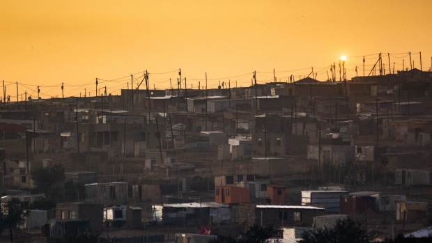 Electricity cables run above residential shacks as the sun rises in the Saulsville township, Pretoria, South Africa, on Friday, May 31, 2019. While South African President Cyril Ramaphosa says power utility Eskom Holdings SOC Ltd. is considered too big to fail, it could be too big to support because of the costs associated with stabilizing its finances, Engineering News reported, citing S&P Global Ratings Director Ravi Bhatia. Photographer: Waldo Swiegers/Bloomberg