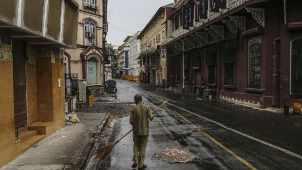 A worker sweeps an empty street during a lockdown imposed due to the coronavirus in Mumbai, India, on Monday, June 1, 2020. Despite a strict two-month-long lockdown, the outbreak in India’s financial capital has snowballed, with the city now accounting for nearly a quarter of India’s more than 4,700 deaths and more a fifth of India’s over 165,000 infections. Photographer: Dhiraj Singh/Bloomberg