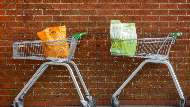 A Sainsbury's and an Asda plastic shopping bag sit in shopping trolleys outside a supermarket in this arranged photograph in Portsmouth, U.K., on Wednesday, Feb. 20, 2019. J Sainsbury Plc's attempt to create the biggest U.K. supermarket chain with the 7.3 billion-pound ($9.5 billion) purchase of Wal-Mart Inc.'s Asda looks close to collapse after antitrust authorities attached harsher-than-expected conditions for approval. Sainsbury shares plunged the most in a decade. Photographer: Luke MacGregor/Bloomberg